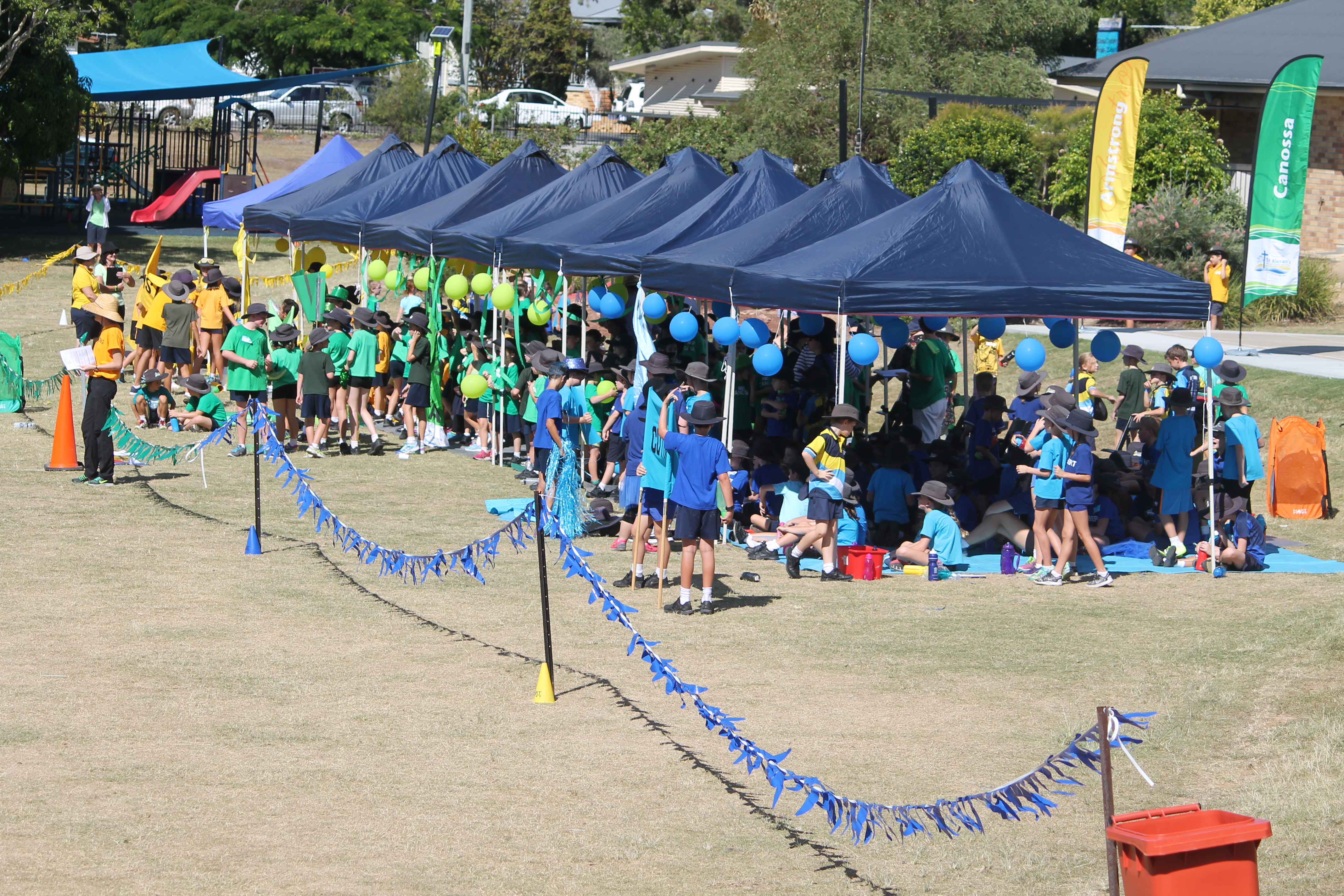 Students gathered under shaded tents during a school sports carnival